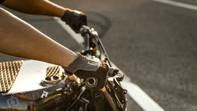 Mano con guante de moto sobre el manillar