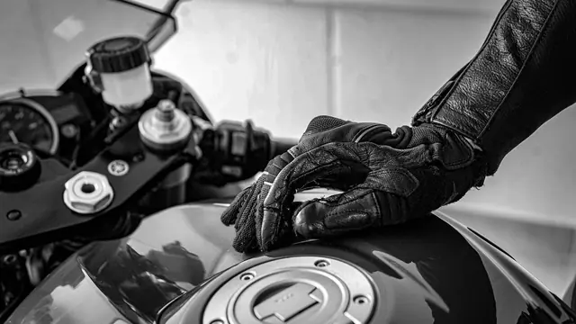Mano con guante sobre el depósito de una moto